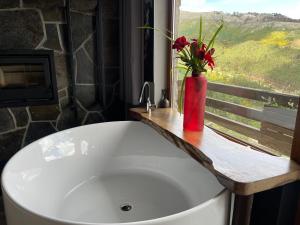 a white bath tub with a vase of flowers in a bathroom at Muas Guest House in Vila Real