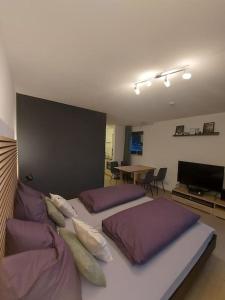 a bedroom with two beds with purple pillows and a table at Ferienwohnung Lina mit toller Terrasse im Schwarzwald in Bernau im Schwarzwald