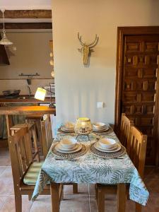 uma mesa de jantar com uma toalha de mesa azul e pratos em Apartamentos Rurales El Pedregoso 
