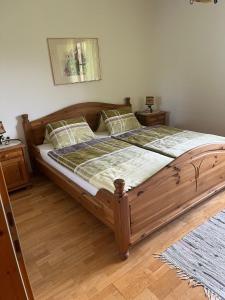 1 cama grande de madera en un dormitorio con 2 mesitas de noche en Dachberghof, en Sankt Andrä