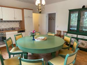 una cucina con tavolo e sedie verdi di Landgut a Vetschau