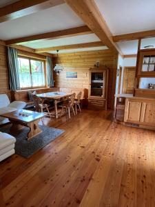een woonkamer met houten vloeren en een tafel en stoelen bij Dachberghof in Sankt Andrä