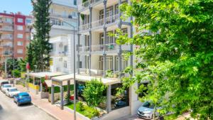 an apartment building on a city street with cars parked at My Home Hotel Gulluk in Antalya