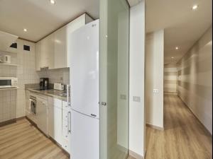 una cucina con armadietti bianchi e frigorifero bianco di Gran Via Terrace Barcelona a Barcellona
