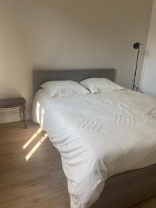 a bedroom with a bed with white sheets and a table at Le Billeron in Saint-Amand-Montrond