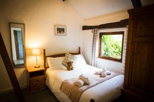 a bedroom with a bed with two teddy bears on it at The Stables at Country Ways in Atherington