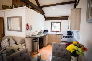 a kitchen with a couch and a table in a room at The Stables at Country Ways in Atherington