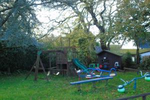 a playground in a yard with a swing set at The Dray at Country Ways in Atherington