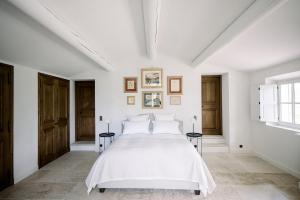 a white bedroom with a white bed and a window at Le Domaine du Fortin in Ménerbes +39 photos