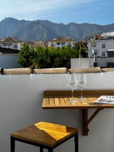 two wine glasses sitting on a table on a balcony at Peral Old Town Penthouse II - EaW Homes in Marbella