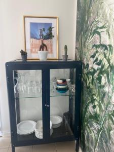 a black cabinet with plates and dishes in it at Beldi, Bel appartement dans un environnement calme in Montgermont