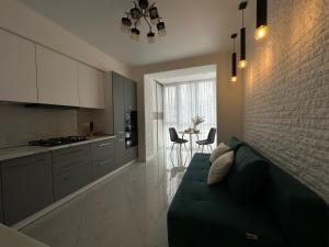 een woonkamer met een bank en een keuken bij Comfort Apartment in Vinnytsya