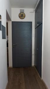 a hallway with a door with a clock on the wall at H22 Apartman in Eger +3 photos