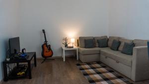a living room with a couch and a guitar at H22 Apartman in Eger