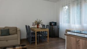 a living room with a table and chairs and a couch at H22 Apartman in Eger