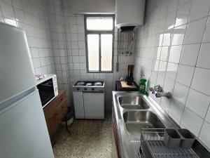 a small kitchen with a sink and a stove at Apartamento 3 dormitorios con aire acondicionado in Granada