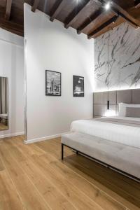 1 dormitorio con cama y pared blanca en Home at Rome Luxury Navona, en Roma