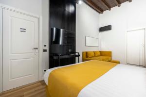 1 dormitorio con 1 cama, TV y silla en Home at Rome Luxury Navona, en Roma