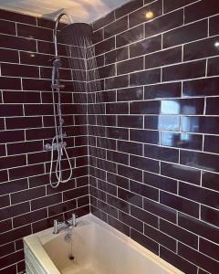 a bathroom with a bath tub with a shower at Chester/Handbridge sleeps 9 + Netflix in Hough Green