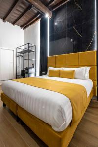 sypialnia z dużym łóżkiem i żółtym kocem w obiekcie Home at Rome Luxury Navona w Rzymie
