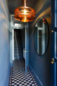 a hallway with a mirror and a blue wall at Chester/Handbridge sleeps 9 + Netflix in Hough Green