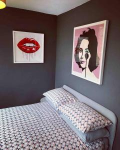 ein Schlafzimmer mit zwei Plakaten an der Wand und einem Bett in der Unterkunft Chester/Handbridge sleeps 9 + Netflix in Hough Green