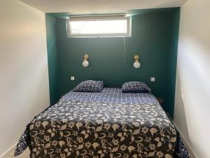 una camera con un letto su una parete verde di Beldi, Bel appartement dans un environnement calme a Montgermont
