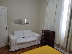 sala de estar con silla blanca y espejo en Apartamento Aluguel, en Salvador