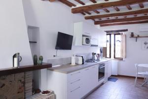 cocina con armarios blancos y encimera en CIRIBACCO ROOMS, en Macerata