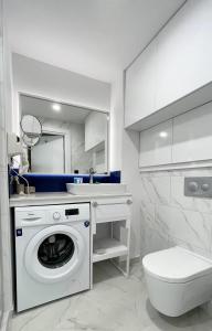 a bathroom with a washing machine and a sink at Apartments Black Sea Resort in Batumi