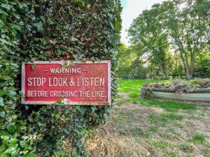 um sinal que está ligado a um arbusto em Old Ningwood Station Bed & Breakfast em Shalfleet