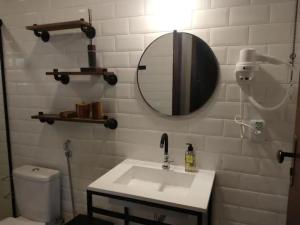 uma casa de banho com um lavatório, um espelho e um WC. em Casa da Serra em Cavalcante