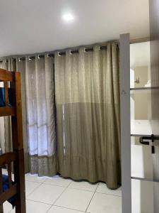 uma janela com uma cortina num quarto em Aconchego de Itaipava - Casa de 3 quartos, ampla, equipada, com área kids, jacuzzi, em meio a Natureza e próximo ao centro do bairro em Petrópolis