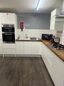 a kitchen with white cabinets and a sink at Hartington House in Middlesbrough