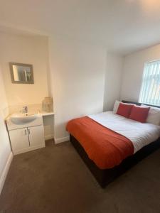 a small bedroom with a bed and a sink at Hartington House in Middlesbrough