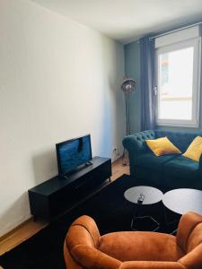 uma sala de estar com um sofá e uma televisão em Meyver Cochem Centrum. em Cochem