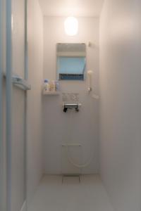 La salle de bains blanche est pourvue de toilettes et d'une fenêtre. dans l'établissement Minpaku Ota - Vacation STAY 11961, à Otaru