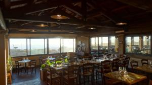 un comedor con mesas, sillas y ventanas en Hotel Tenuta dell'Argento Resort, en Civitavecchia