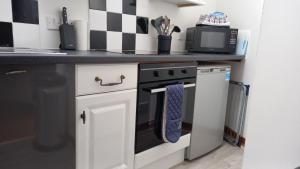 a kitchen with a black and white checkered wall at North End The Cottage in Nairn
