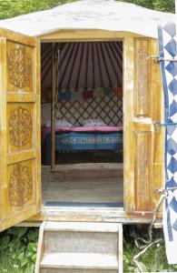 an open door to a bed in a tent at La Yourte du Masfranc in Latour-de-Carol