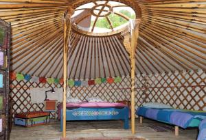 a yurt with two beds and a window at La Yourte du Masfranc in Latour-de-Carol