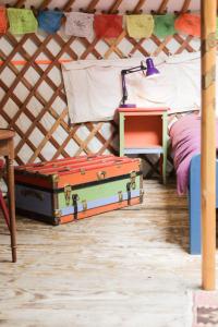 a room with a bed and a suitcase on the floor at La Yourte du Masfranc in Latour-de-Carol