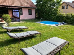 un patio trasero con 2 chaises y una piscina en Chalupa Měňany - Karlštejn, en Beroun