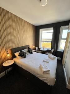 um quarto com uma cama com duas mesas e duas janelas em OYO Marine Parade Hotel, Eastbourne Pier em Eastbourne