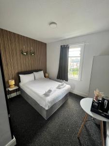 1 dormitorio con cama blanca y ventana en OYO Marine Parade Hotel, Eastbourne Pier en Eastbourne