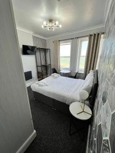 a hotel room with a bed and a table and chairs at OYO Marine Parade Hotel, Eastbourne Pier in Eastbourne +113 photos
