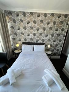 a bedroom with a white bed with two towels on it at OYO Marine Parade Hotel, Eastbourne Pier in Eastbourne