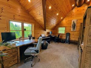 una oficina con escritorio y sillas en una cabaña en WML stunning log home in Bretton Woods, AC, 2-person Jacuzzi, indoor and outdoor fireplaces, & more!, en Bretton Woods