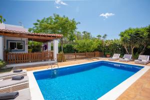 a swimming pool with chairs and a house at Casa Can Ferran in Nuestra Señora de Jesus