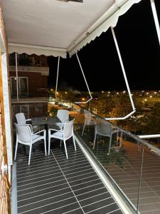 a table and chairs on a balcony at night at Fishta apartments Q5 34 in Velipojë